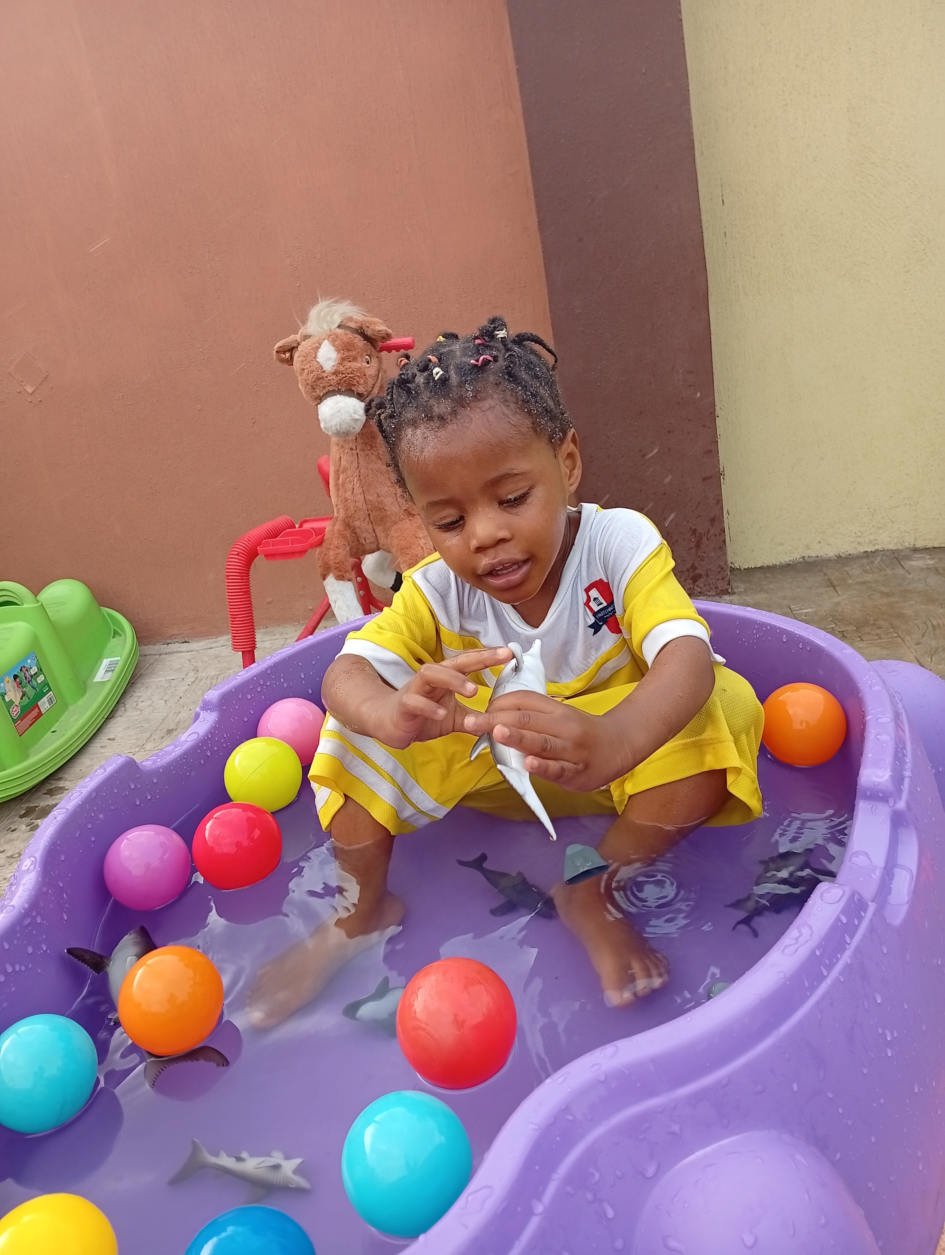A creche pupil learning through supervised water play